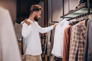 Young man shopping at menswear store and talking on the phone